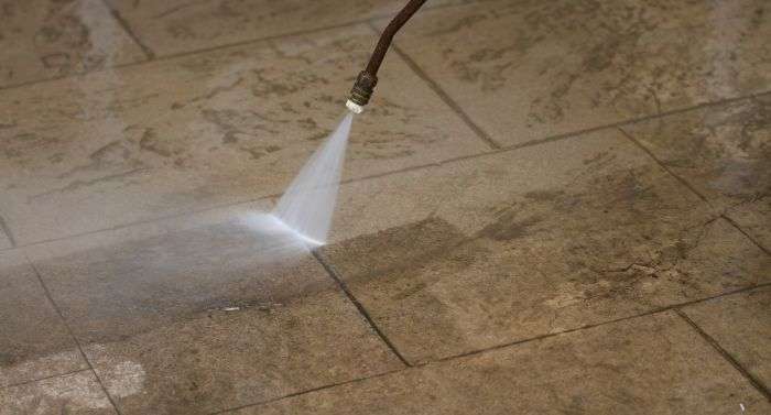 pressure washer spraying pavers